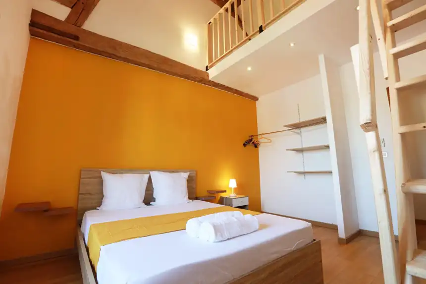 Chambre préparée, lit fait avec linge blanc et serviettes roulées