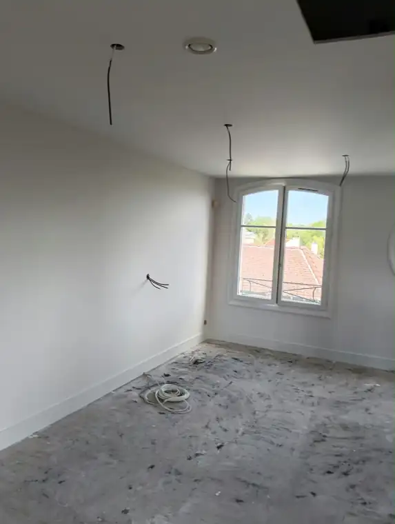 Chambre aux murs et plafond peints en blanc, plinthes et fenêtre laquées