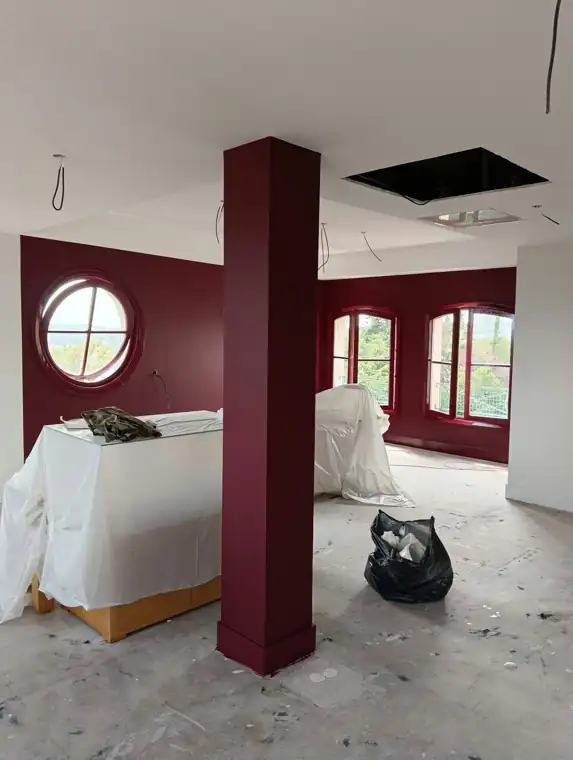 Pièce mise en couleur bordeaux, poteau et menuiseries laquées, mobilier protégé